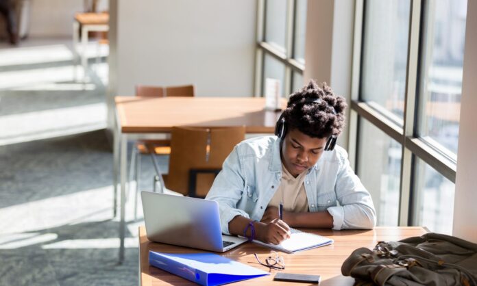 Teenage boy studies in school library