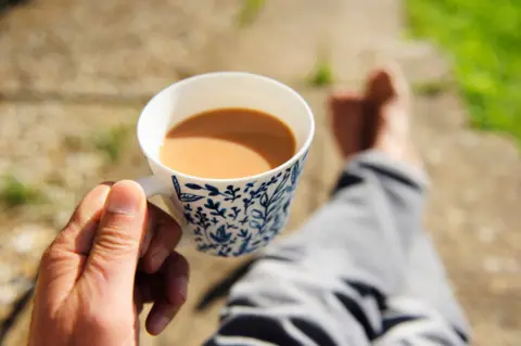 Getty Images Close-up of senior person's hand holding a cup of tea