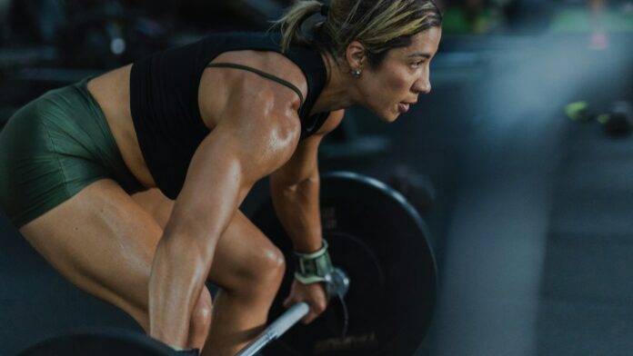 A woman lifting a loaded barbell in a gym