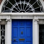 The 21-day habit rule came from a plastic surgeon’s book preface A woman walking past a blue door on a brick building