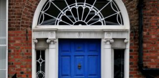The 21-day habit rule came from a plastic surgeon’s book preface A woman walking past a blue door on a brick building