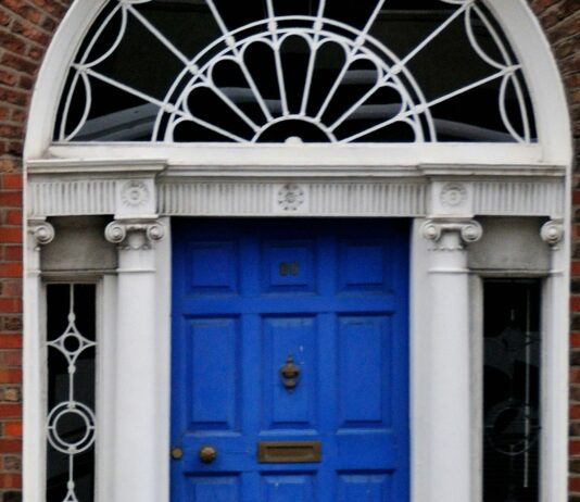 The 21-day habit rule came from a plastic surgeon’s book preface A woman walking past a blue door on a brick building