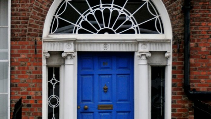 blue-door-habit A woman walking past a blue door on a brick building