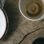 Breakfast is not the most important meal of the day Used breakfast dishes and a crumpled napkin on a wooden table