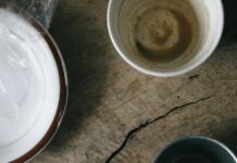 Breakfast is not the most important meal of the day Used breakfast dishes and a crumpled napkin on a wooden table