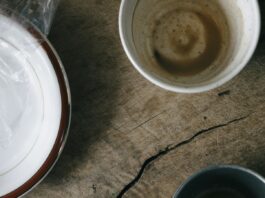 Breakfast is not the most important meal of the day Used breakfast dishes and a crumpled napkin on a wooden table