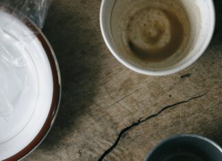 Breakfast is not the most important meal of the day Used breakfast dishes and a crumpled napkin on a wooden table