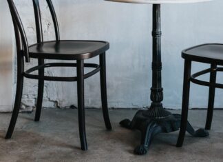 Two chairs and a small table against a white wall