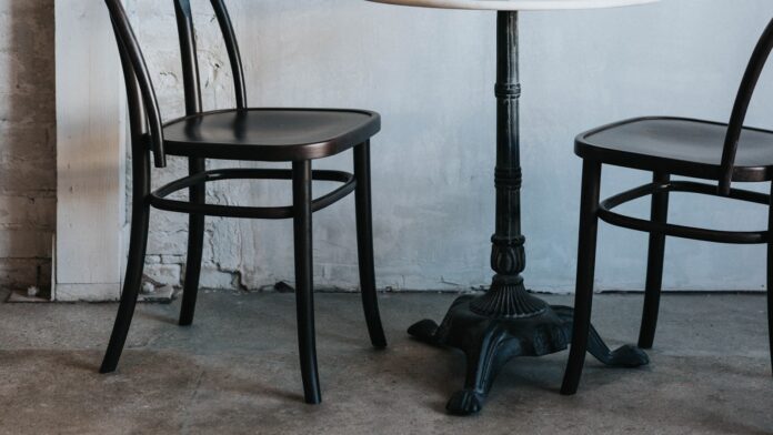 chairs-wide Two chairs and a small table against a white wall