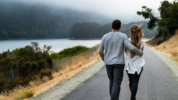 A man and woman walking together along a road