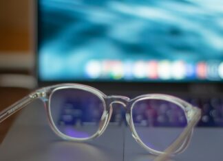 A pair of silver-framed eyeglasses resting on a white table