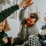 Two Researchers Disagreed About Money and Happiness. So They Ran the Study Together. Four friends laughing together over coffee