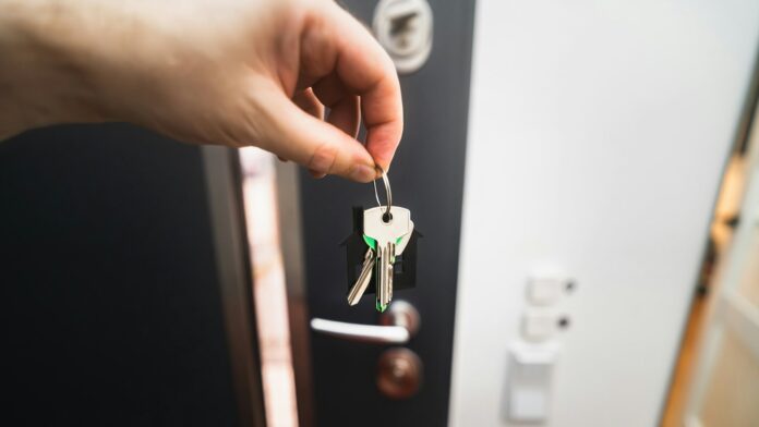 key-in-door A person holding a key to a door