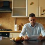 A man reading a document at a kitchen table