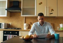 Where the three-to-six-month emergency fund rule actually came from A man reading a document at a kitchen table