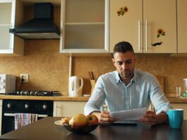 Where the three-to-six-month emergency fund rule actually came from A man reading a document at a kitchen table