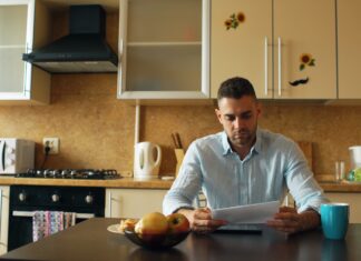 Where the three-to-six-month emergency fund rule actually came from A man reading a document at a kitchen table