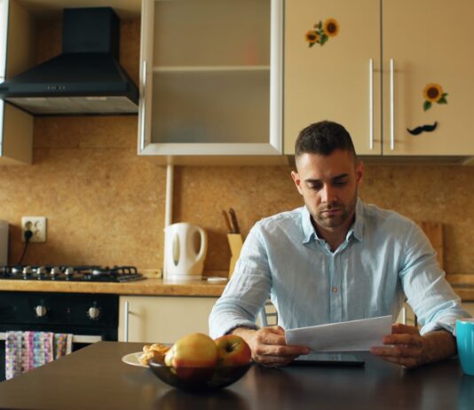 Where the three-to-six-month emergency fund rule actually came from A man reading a document at a kitchen table