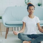 The Meditation Researchers Auditing Their Own Field A young woman sitting cross-legged meditating on the floor at home