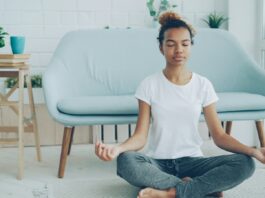The Meditation Researchers Auditing Their Own Field A young woman sitting cross-legged meditating on the floor at home