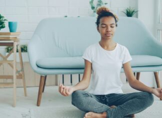 The Meditation Researchers Auditing Their Own Field A young woman sitting cross-legged meditating on the floor at home