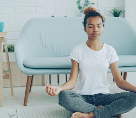 The Meditation Researchers Auditing Their Own Field A young woman sitting cross-legged meditating on the floor at home