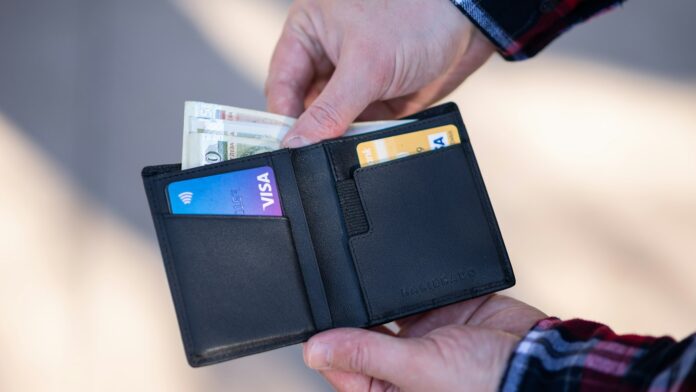 wallet-cards A black leather bifold wallet held open in a person's hand