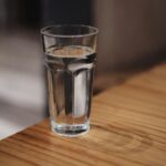 The eight-glasses rule is a sentence someone deleted A glass of water on a wooden surface