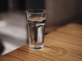 The eight-glasses rule is a sentence someone deleted A glass of water on a wooden surface
