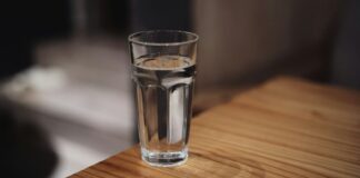 The eight-glasses rule is a sentence someone deleted A glass of water on a wooden surface