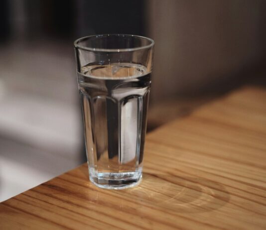 The eight-glasses rule is a sentence someone deleted A glass of water on a wooden surface