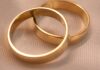 The 50% Divorce Rate Was True for About One Year. You Can Name It. Two interlocking gold wedding bands on a textured surface